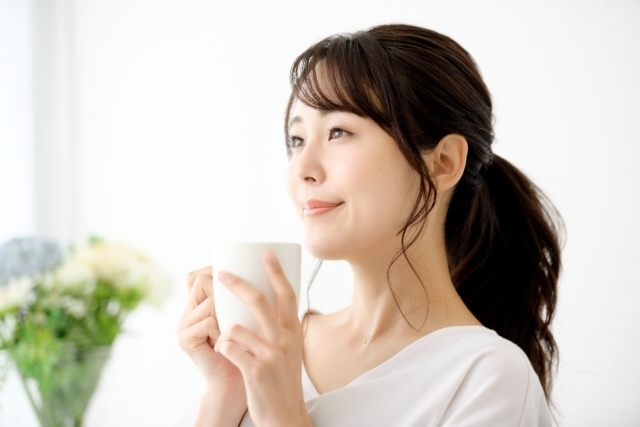 マグカップを持ってリラックスして微笑む女性